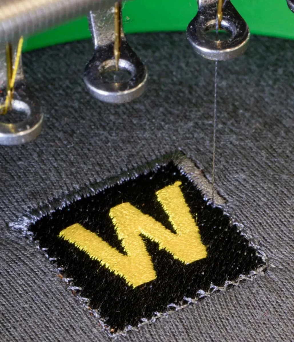 Industrial embroidery machine stitching company logo onto workwear — embroidery Slough